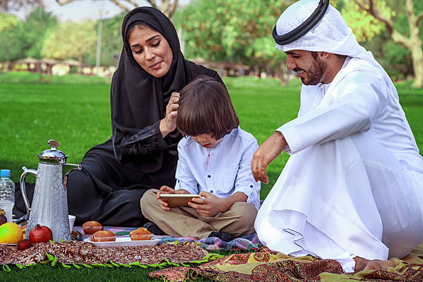 istock Young Arabic family using digital tablet at park 476020134