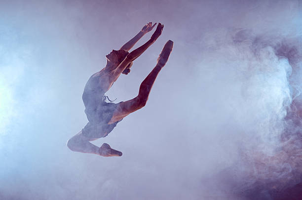 istock Beautiful young ballet dancer jumping on a lilac background 476021866
