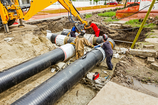 Team of workers in trench working hard to install a new pipeline