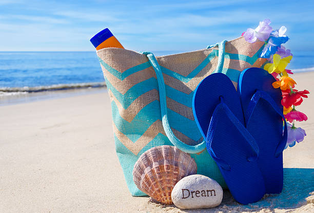 istock Beach bag with flip flops by the ocean 476030025