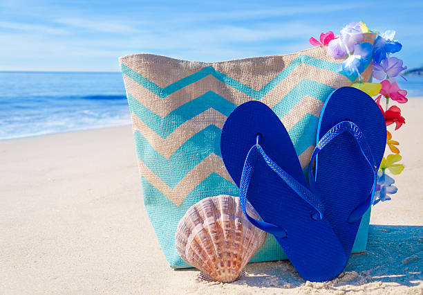istock Beach bag with flip flops by the ocean 476030031