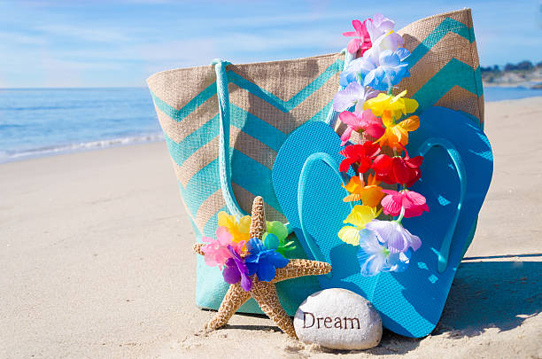 Beach bag with flip flops by the ocean