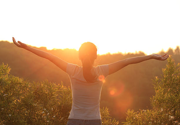 istock free woman open arms to sunrise 476031417