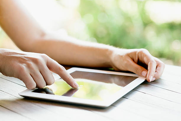 istock Hands busy with digital tablet placed on outdoor table 476033805