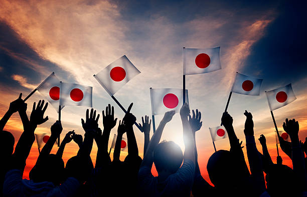 siluetas de personas sosteniendo la bandera de japón - japanese flag fotos fotografías e imágenes de stock