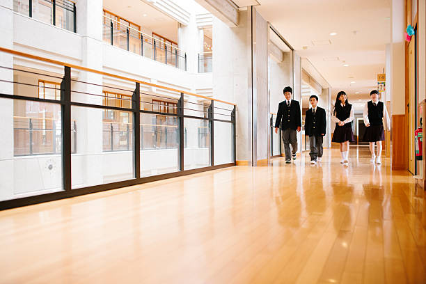 istock Japanese high school. Four students walk through corridor, front view 476040844