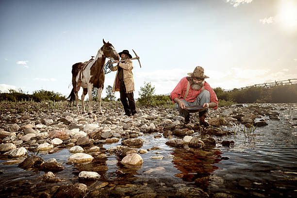 Gold Rush! Two prospectors panning for gold at a river in the mountains panning for gold photos stock pictures, royalty-free photos & images