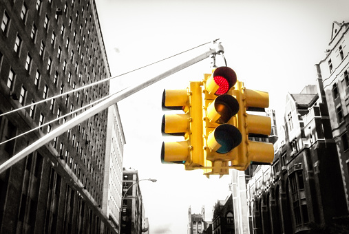 Yellow New York traffic light on red, with black and white background - colour pop