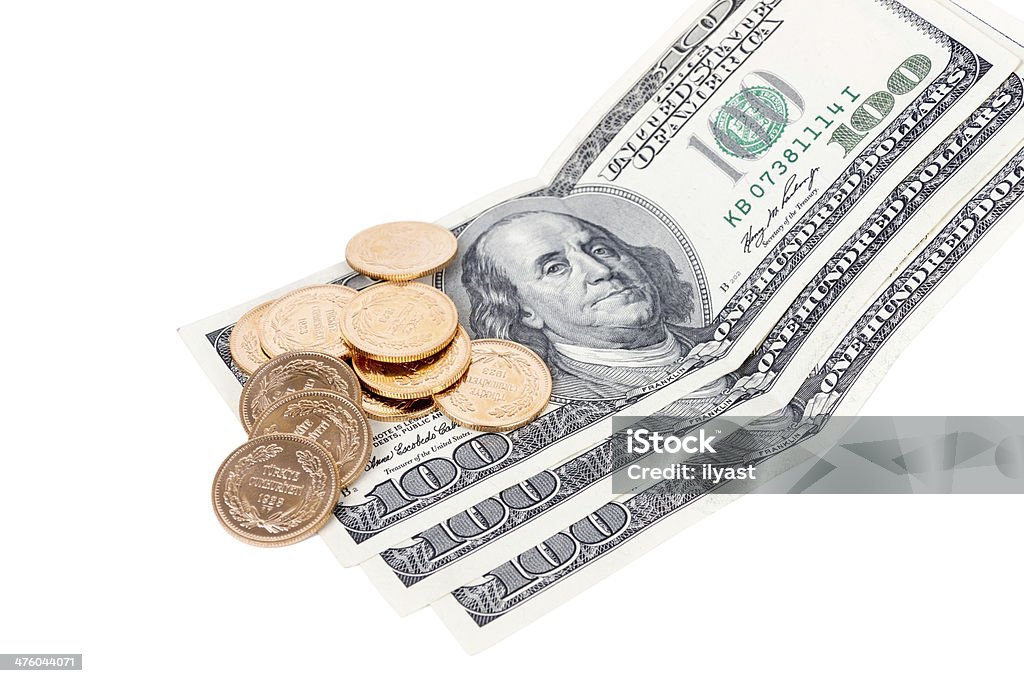 Gold Over Money Gold coins scattered on top of one hundred dollar bills close up. Dollar Sign Stock Photo