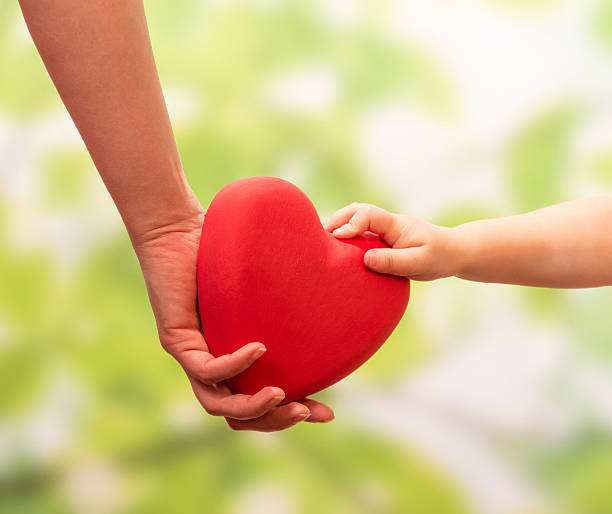 istock Man and child hands holding heart 476044650