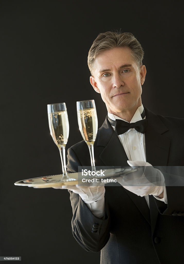 Pewnie Kelner trzyma tacę z szampana rowków - Zbiór zdjęć royalty-free (Czarne tło)