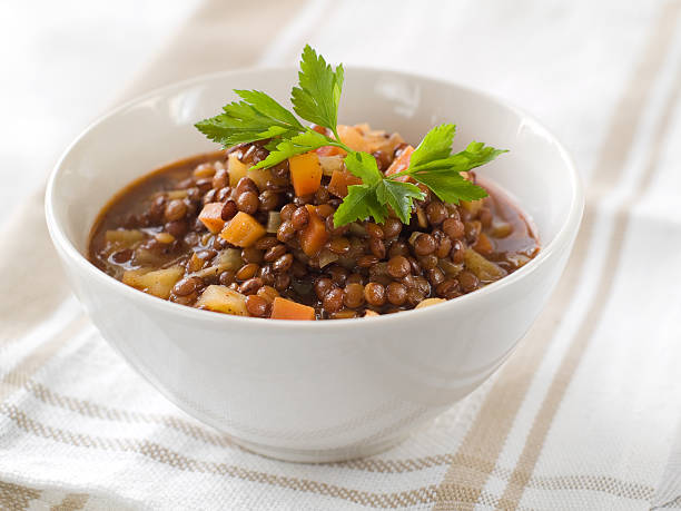 lentil stew Brown lentil stew in bowl with vegetable, selective focus lentil stock pictures, royalty-free photos & images