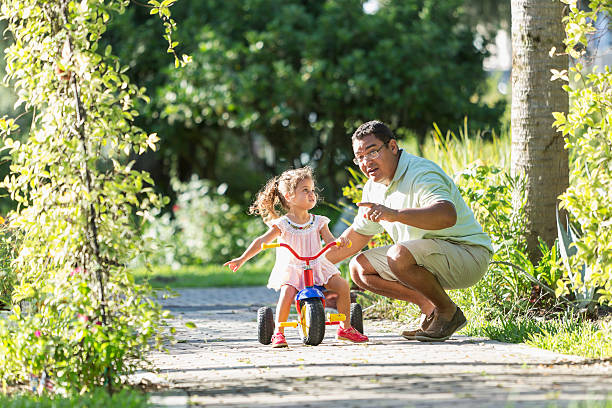 istock Little girl riding tricycle with daddy 476065231