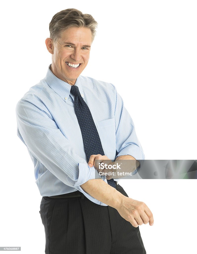 Happy Businessman Rolling Up His Sleeves Portrait of happy mature businessman rolling up his sleeves while standing against white background Portrait Stock Photo