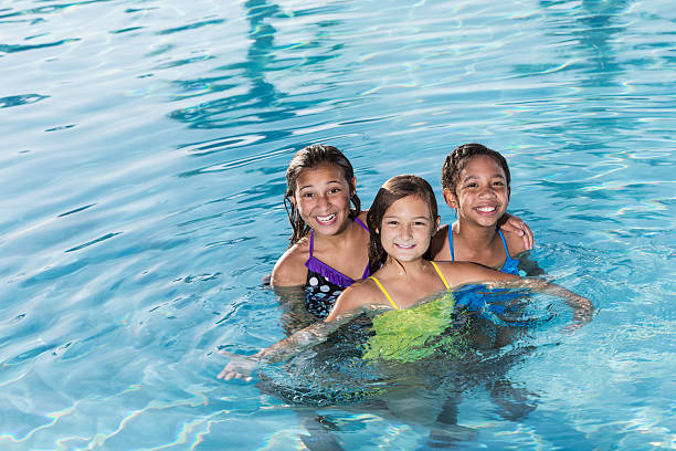 istock Girls playing in swimming pool. 476072883
