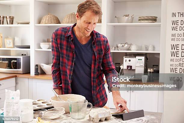 Middle Aged Man Reading Recipe On Tablet Computer Stock Photo - Download Image Now - Baking, Men, Only Men