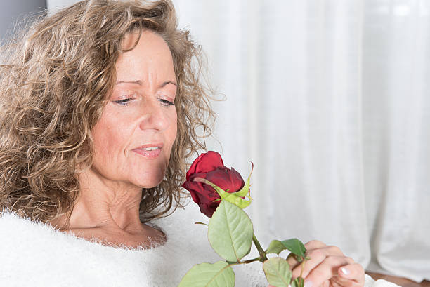 istock woman looks at rose 476082138