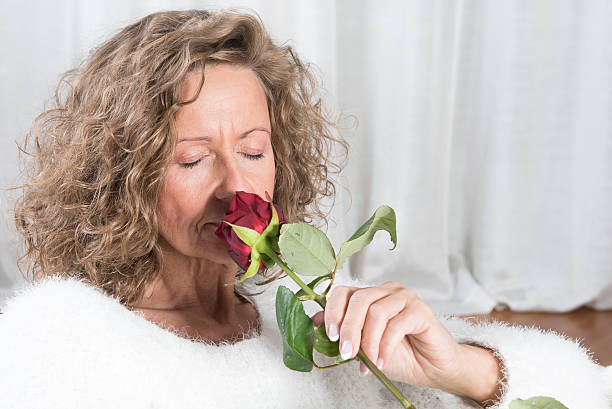 istock woman smells rose 476082140