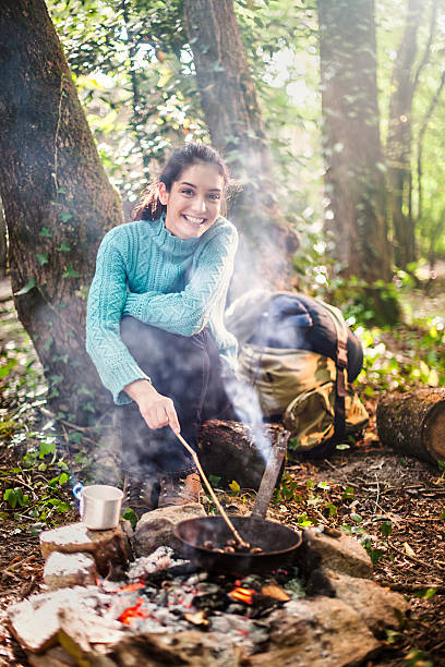 istock young woman cooking on a campfire 476082706
