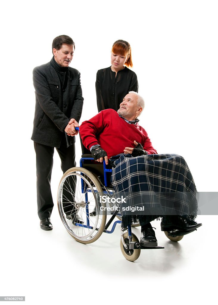 Man on wheelchair old man on wheelchair with younger man and woman, 2015 Stock Photo