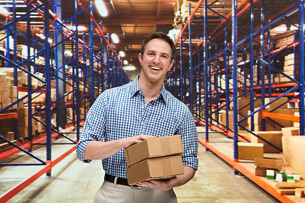 istock Smiling businessman in warehouse holding package 476082742