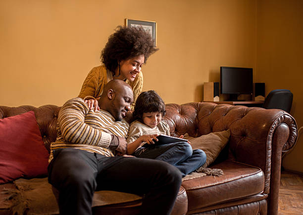 istock Smiling African American family using digital tablet at home. 476083656