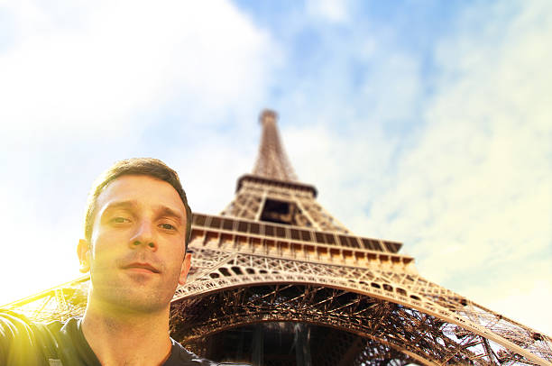 istock Young man taking selfy photo in front of Eiffel Tower 476084028