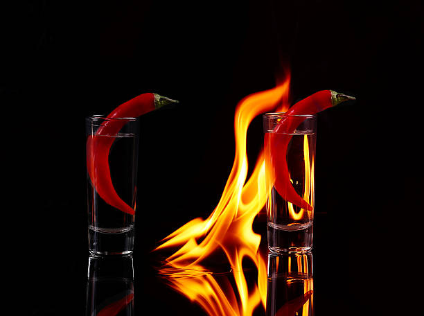 istock Hot chili pepper in a shot  glass with a fire 476084098