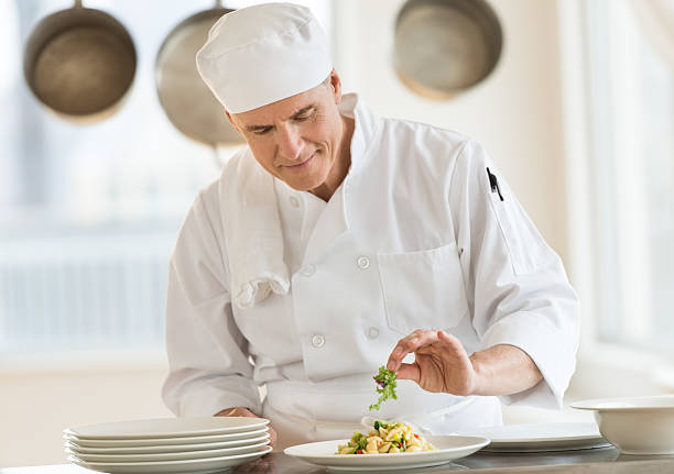 istock Chef Garnishing Dish In Commercial Kitchen 476084255