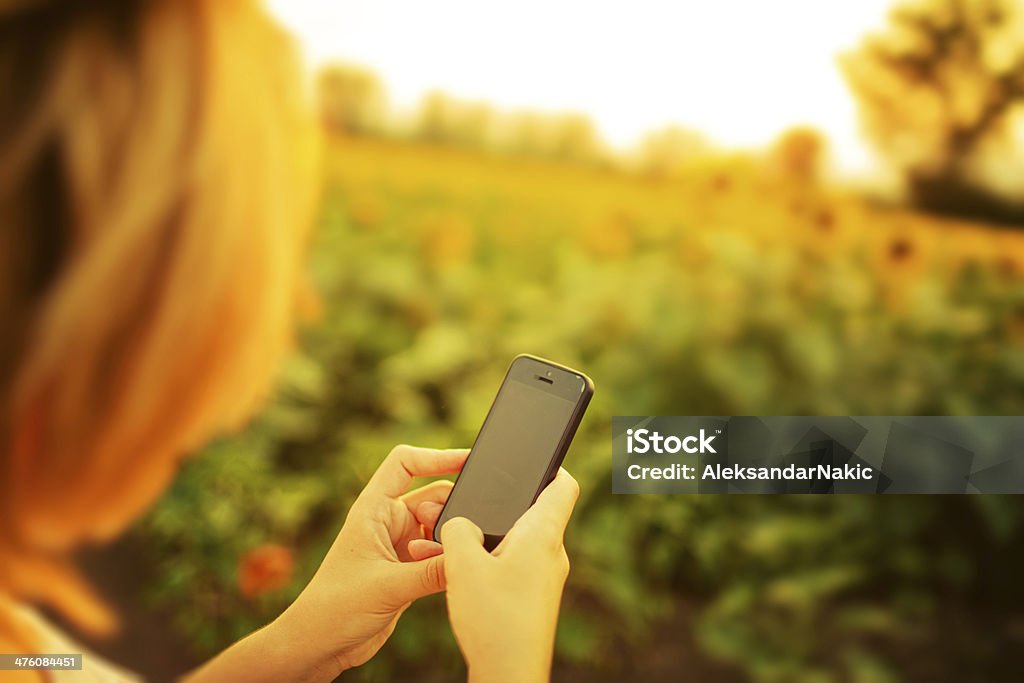 Utilizar um smartphone ao ar livre - Royalty-free Adulto Foto de stock