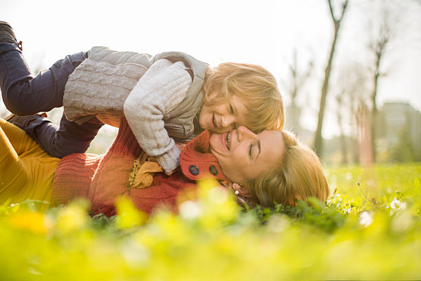 istock Playful mother and son lying in the grass and laughing. 476089270