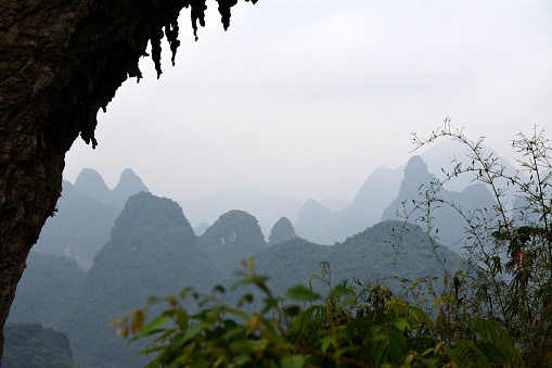Stunning Karst landscape view from Moon Hill, a hill with a natural arch, on a cloudy day. It's located a few kilometers outside Yangshuo in southern China's Guangxi autonomous region. It is so named for a wide, semicircular hole through the hill.