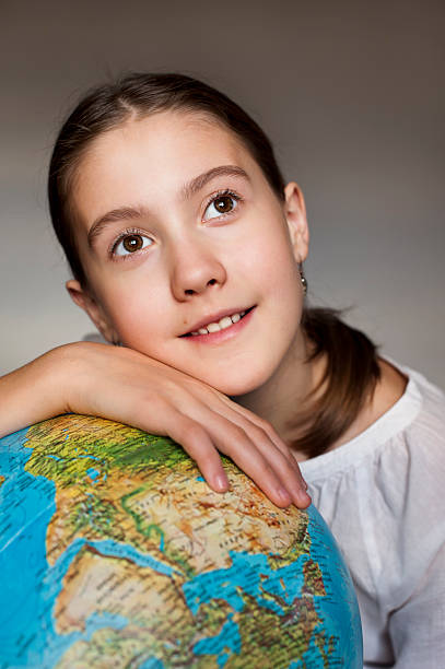 istock Dreaming smiling girl with blue globe 476092231