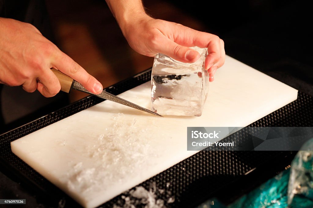 Bartender Carving Ice Bartender Carving Ice for a Cocktail 2015 Stock Photo