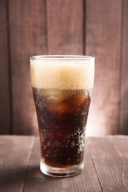 istock Cola in glass with ice on wooden background 476097052