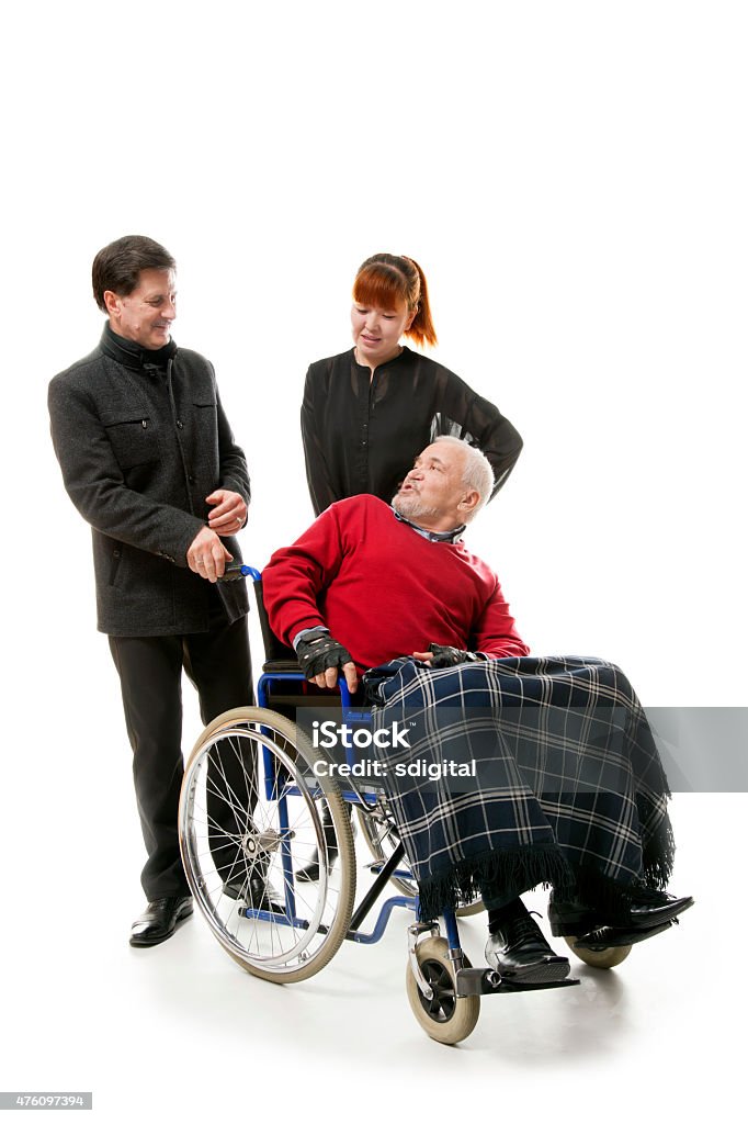 Man on wheelchair old man on wheelchair with younger man and woman, 2015 Stock Photo