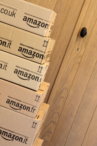 Antwerpen, Belgium - February 25, 2014: A stack of Amazon EU boxes at the door. Amazon is the world's largest online retailer.