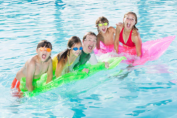 istock Family playing in swimming pool 476098775