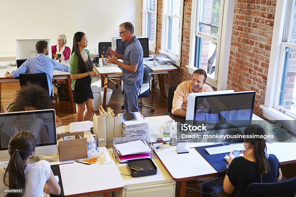 Wide Angle View Of Busy Design Office With Workers Wide Angle View Of Busy Design Office With Workers At Desks Office Stock Photo