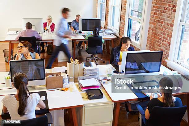 Busy Office Setting With Employees At Computers Stock Photo - Download Image Now - Office, Open Plan, Busy