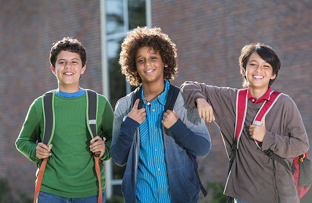 ragazzi in piedi fuori scuola - three boys foto e immagini stock