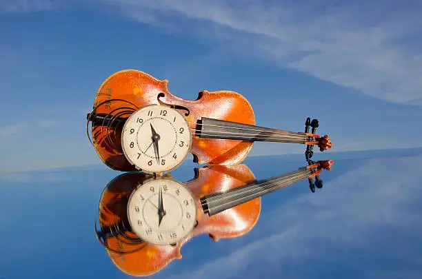 old violin and clock-face on mirror
