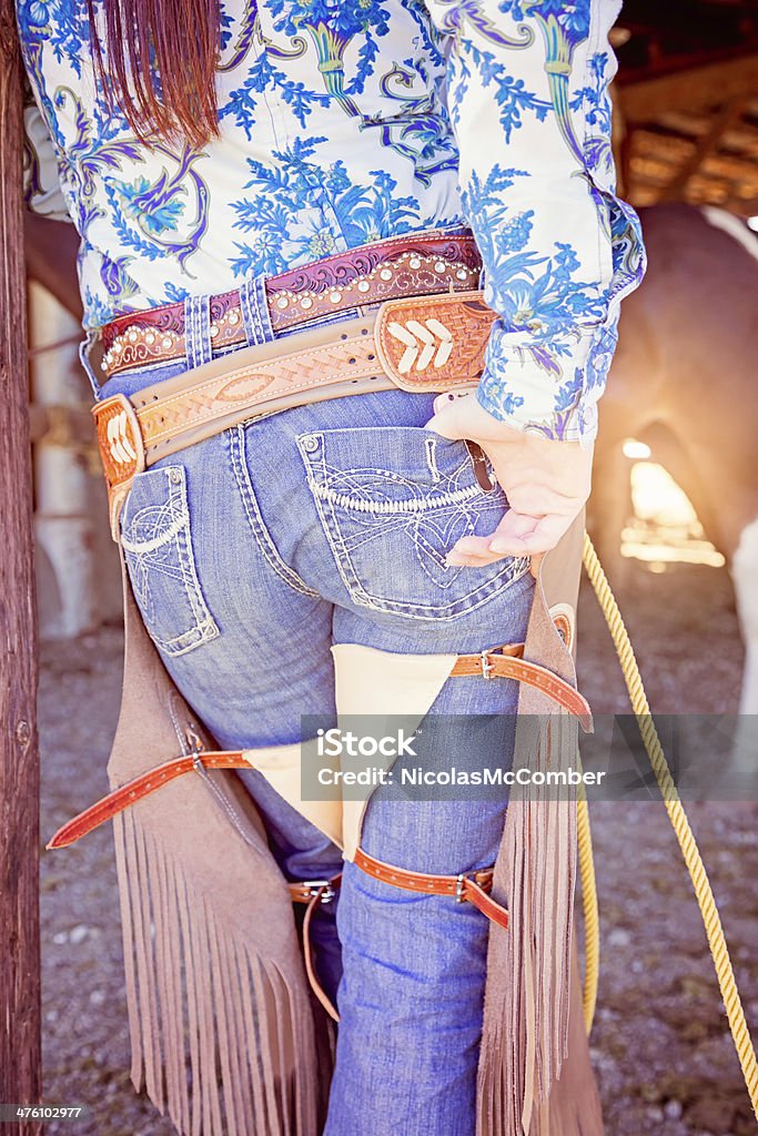 Vista posteriore da Cowgirl s Gambali di cuoio nel Recinto per bestiame - Foto stock royalty-free di Abbigliamento casual