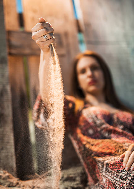 istock Woman pouting sand from her hand. 476107510