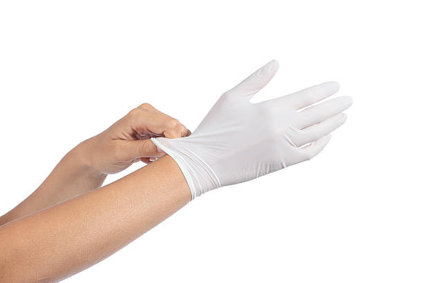 Woman hands putting on a latex gloves stock photo