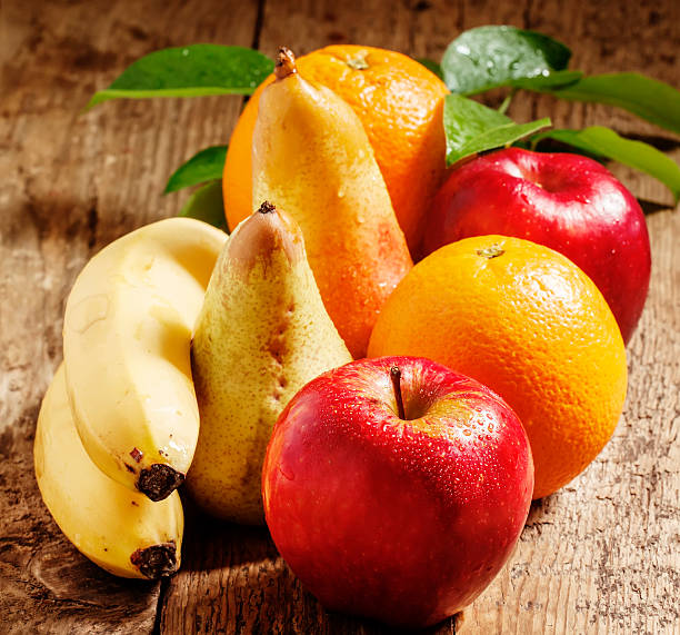 istock Colored fruits on wooden table 476108354