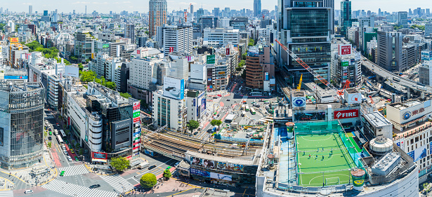 Aerial panorama of the Tokyo skyline with the Shibuya crossing a rooftop sports field