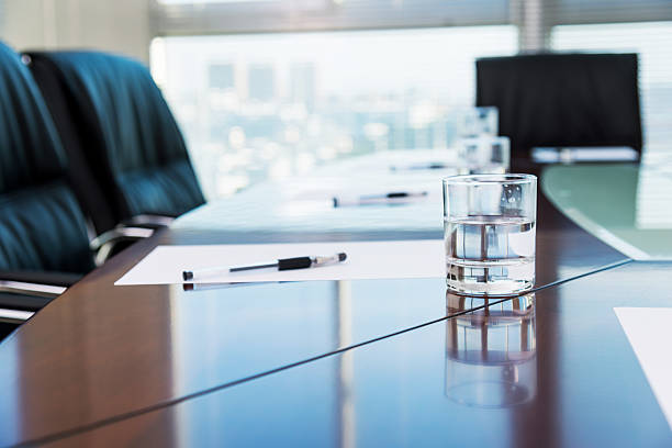 Conference room Conference room with blank papers and water glass. shareholders meeting stock pictures, royalty-free photos & images