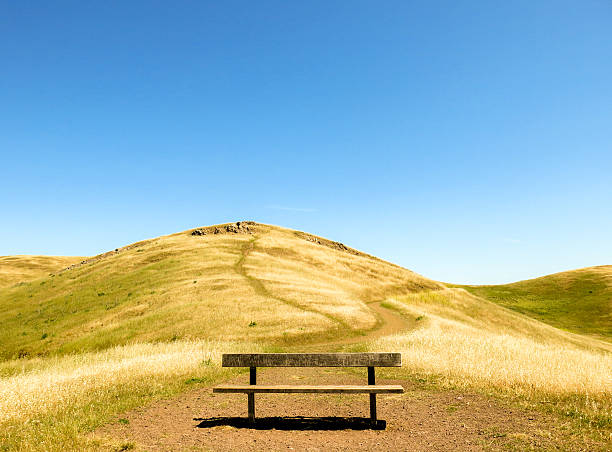 Lonely bench on a dry mountain path stock photo