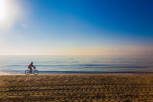 istock Woman cycling along a beach 476121391